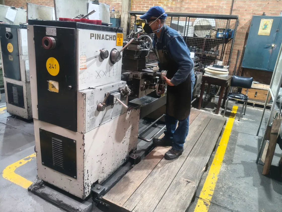Operario trabajando en un torno de la planta de COREL